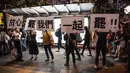 Demonstran menunjukkan pesan tuntutan mereka saat ribuan pegawai negeri sipil (PNS) mengikuti unjuk rasa menolak RUU Ekstradisi di Hong Kong, Jumat (2/8/2019). Banyak PNS yang memakai topeng hitam untuk menyembunyikan identitas mereka. (LAUREL CHOR/AFP)