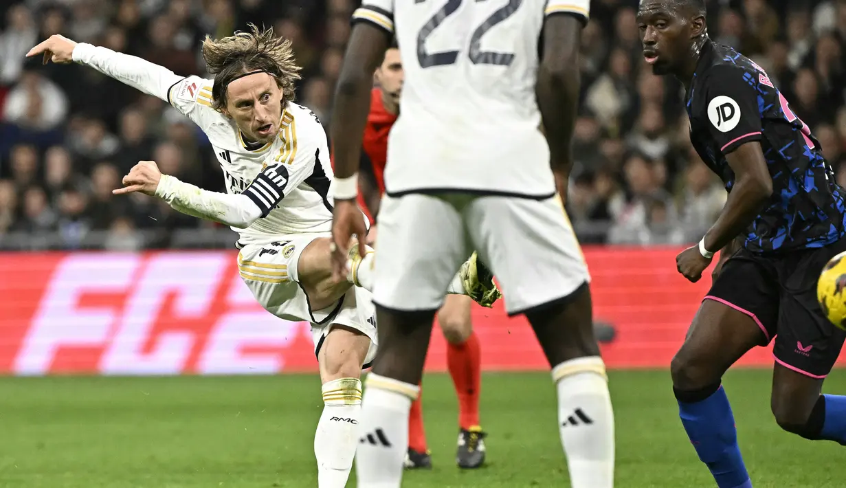 Pemain Real Madrid, Luka Modric mencetak gol ke gawang Sevilla dari luar kotak penalti pada laga lanjutan Liga Spanyol 2023/2024 di Stadion Santiago Bernabeu, Madrid, Spanyol, Senin (26/02/2024) dini hari WIB. Los Blancos menang dengan skor 1-0. (AFP/Javier Soriano)
