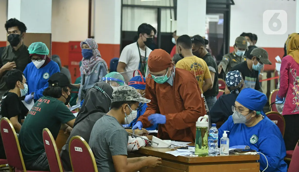 Warga mengantre untuk mendapatkan vaksin Covid-19 di Gelanggang Olahraga (GOR) Ciracas, Jakarta Timur, Kamis (24/6/2021). GOR Ciracas resmi ditunjuk menjadi sentra vaksinasi Covid-19 untuk kelompok usia 18-50 tahun di wilayah Jakarta Timur. (Liputan6.com/Herman Zakharia)