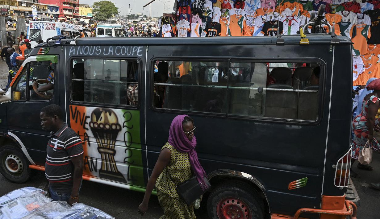 Sebuah mobil van berhiaskan trofi Piala Afrika melewati salah satu pasar di Abidjan, pusat kota Pantai Gading menjelang Piala Afrika 2023 pada Sabtu (06/01/2024) waktu setempat.. (AFP/Issouf Sanogo)