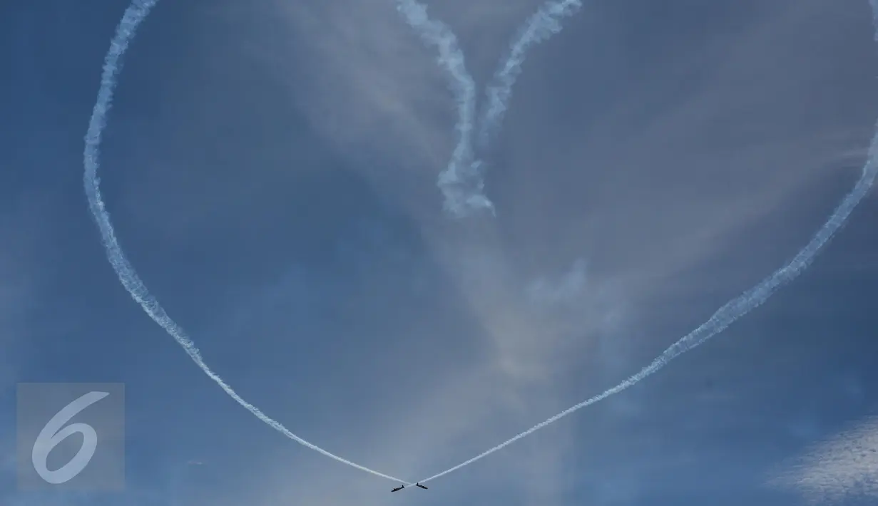 Aksi aerobatik udara Jupiter Aerobatic Team (JAT) yang membentuk love dalam perayaan HUT TNI Angkatan Udara (TNI AU) ke-71 di Landasan Udara (Lanud) Bandara Halim Perdanakusuma, Jakarta, Minggu (9/4). (Liputan6.com/Faizal Fanani)