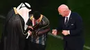 Sebelum prosesi pemberian trofi Piala Dunia, Lionel Messi sempat dipakaikan Abaya oleh Emir Qatar, Tamim bin Hamad al-Thani. (AFP/Jewel Samad)