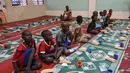 Anak-anak muslim menunggu waktu berbuka puasa di hari kedua bulan suci Ramadhan di sebuah masjid di Treicheville, komune populer di Abidjan pada 24 Maret 2023. (AFP/Sia KAMBOU)