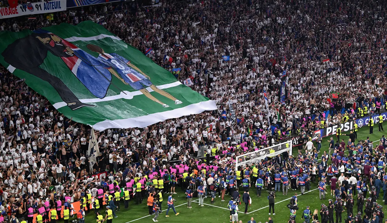 Suporter PSG membentangkan poster bergambar Luis Enrique dan mendiang putrinya, Xana setelah laga final Liga Champions 2024/2025 melawan Inter Milan di Allianz Arena, Munchen, Jerman, Minggu (01/06/2025) dini hari WIB. (AFP Kirill Kudryavtsev)