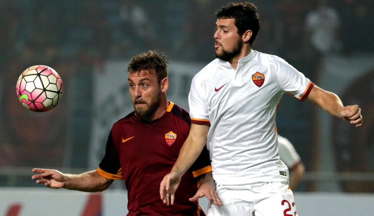 Danielle De Rossi (kiri) berebut bola dengan Mattia Destro. (EPA/Mast Irham)