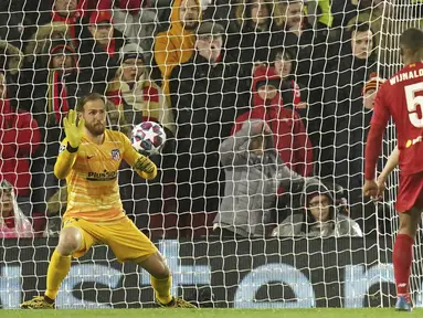 Kiper Atletico Madrid, Jan Oblak menahan bola tendangan striker Liverpool, Roberto Firmino pada pertandingan leg kedua 16 besar Liga Champions di Anfield, Inggris (11/3/2020). Oblak melakukan sembilan penyelamatan dipertandingan ini dan membawa atletico ke perempat final. (AP Photo/Jon Super)