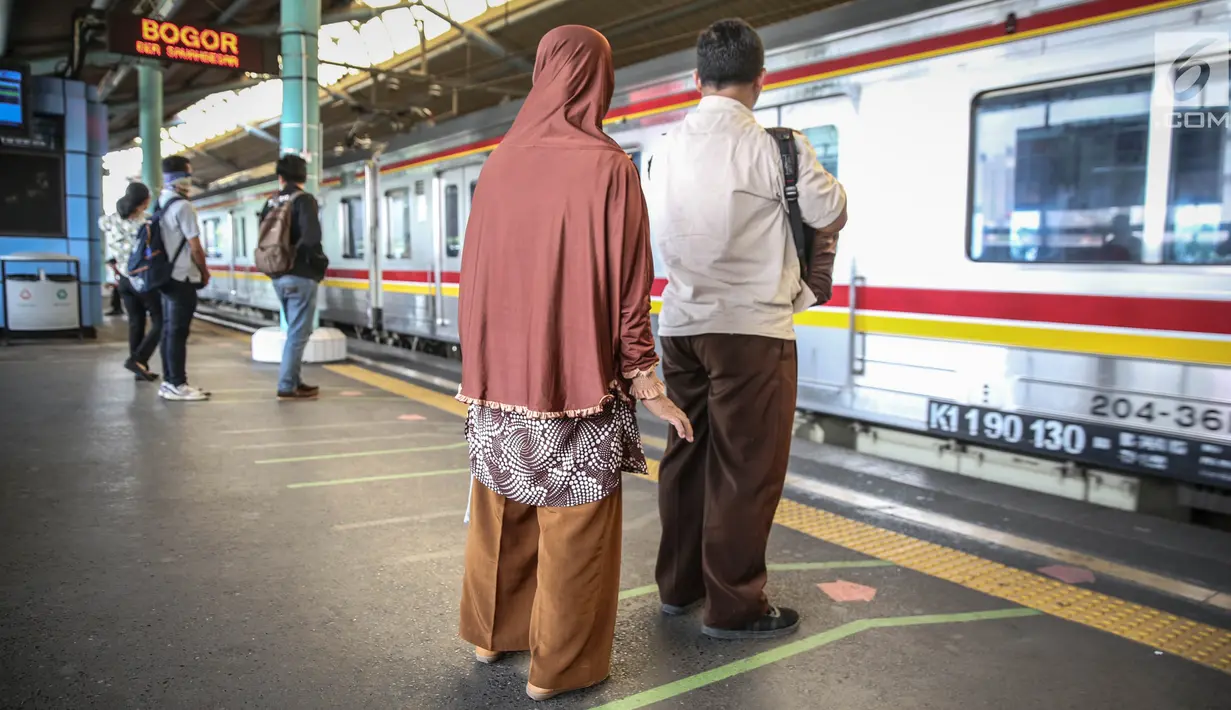 Penumpang berdiri di garis antrean penumpang di Stasiun Juanda, Jakarta, Kamis (10/8). PT KAI Commuter Jabodetabek melakukan uji coba garis antrean penumpang tersebut guna untuk keselamatan bagi para penumpang. (Liputan6.com/Faizal Fanani)