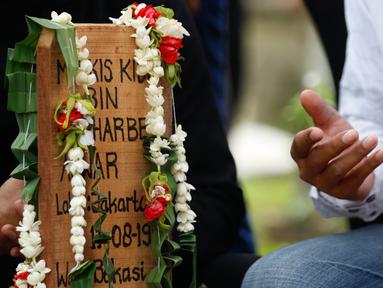 Kerabat dari legenda bulutangkis Indonesia, Markis Kido memberikan doa didepan pusara di TPU Kebon Nanas, Cipinang, Jakarta, Selasa (15/6/2021). (Foto: Bola.com/Bagaskara Lazuardi)