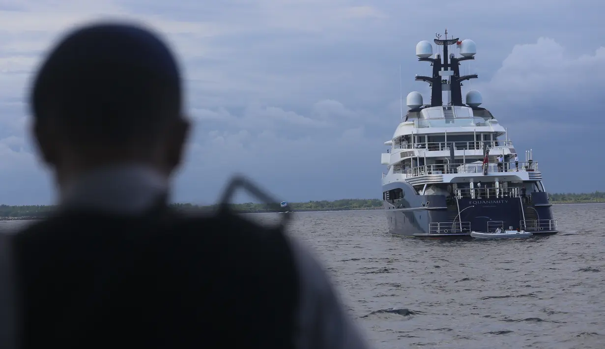 Polisi setempat mendekati sebuah kapal pesiar mewah (yacht) bernama Equanimity yang tengah berada di Teluk Benoa, Bali, Rabu (28/2). Berdasarkan Pengadilan AS, kapal Equanimity dimiliki oleh seorang miliuner asal Malaysia Jho Low. (Rully Prasetyo/AFP)