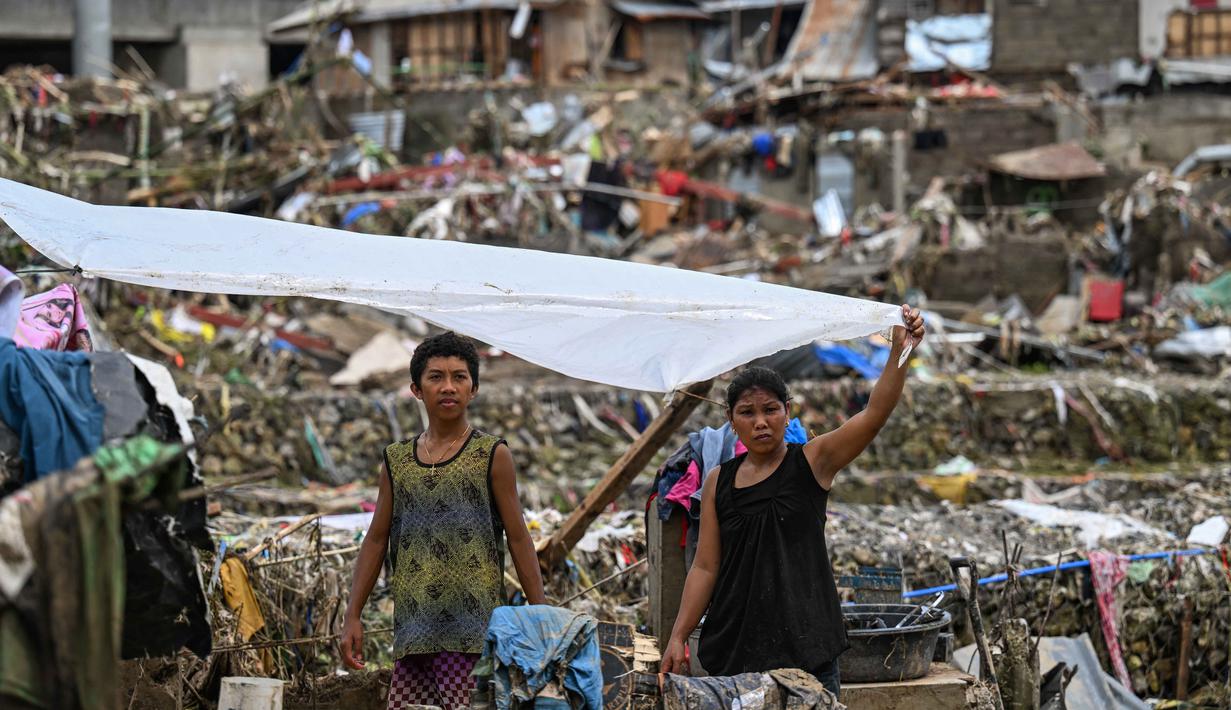 Warga membangun kembali rumah-rumah mereka yang rusak akibat terjangan Topan Kalmaegi di Talisay, Provinsi Cebu, Filipina pada Rabu 5 November 2025. Kondisi makin berat karena provinsi tersebut masih dalam tahap pemulihan dari gempa 6,9 magnitudo pada 30 September lalu yang menewaskan sedikitnya 79 orang dan merusak ribuan rumah. (Jam STA ROSA/AFP)