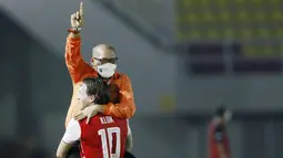 Pelatih Persija Jakarta, Sudirman, melakukan selebrasi bersama Marc Klok, usai menjuarai Piala Menpora 2021 di Stadion Manahan, Solo, Minggu (25/4/2021). (Bola.com/M Iqbal Ichsan)