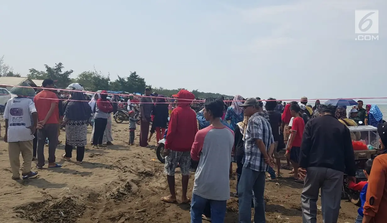 Warga berkerumun menantikan evakuasi pesawat Lion Air JT 610 di Pantai Pakis Jaya, Karawang, Jawa Barat, Senin (29/10). Pesawat Lion Air JT 610  yang jatuh di Karawang buatan tahun 2018. (Liputan6.com/Herman Zakharia)