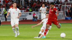 Pemain Timnas Indonesia, Yakob Sayuri berusaha melewati pemain Vietnam, Nguyen Tuan Anh dalam laga leg pertama babak semifinal Piala AFF 2022 di Stadion Utama Gelora Bung Karno (SUGBK), Jumat (6/1/2023) sore WIB. (Bola.com/M Iqbal Ichsan)