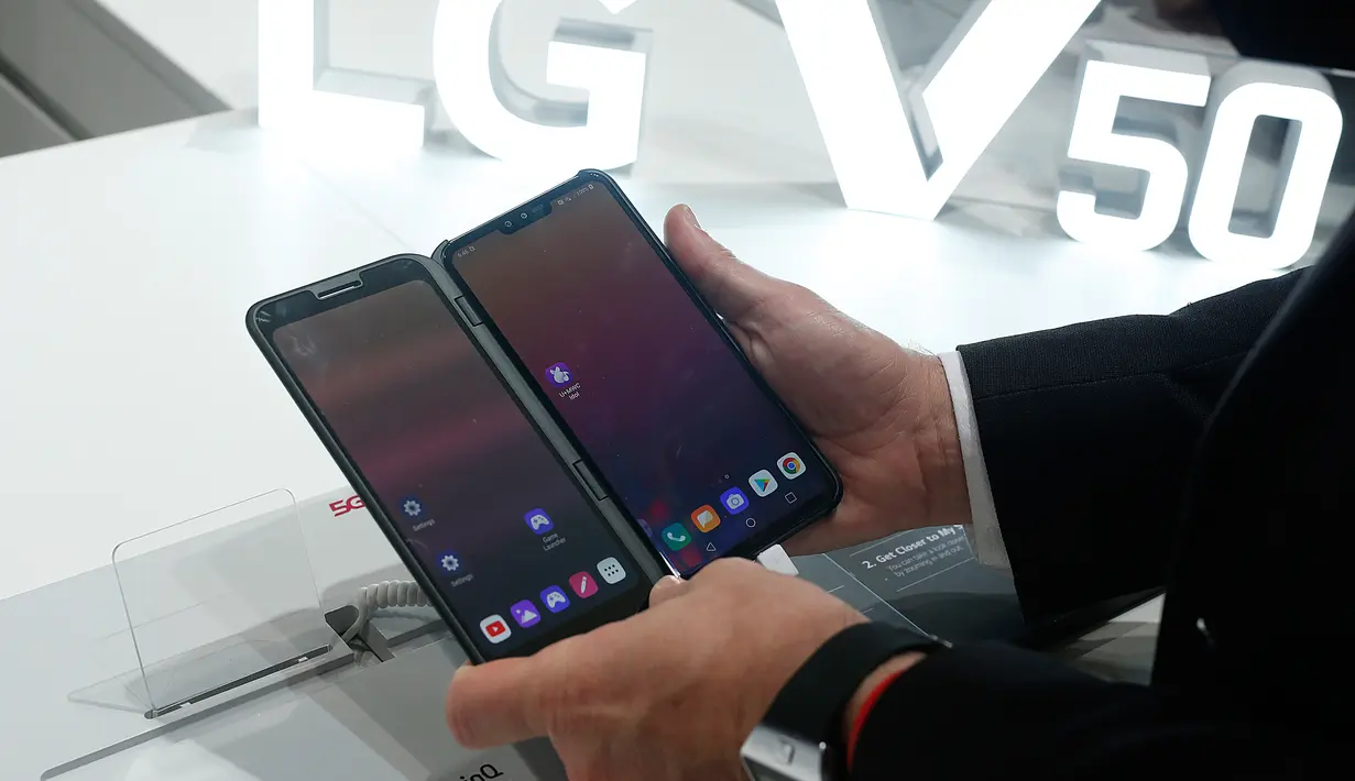 Pengunjung memeriksa smartphone LG V50 ThinQ 5G dalam gelaran Mobile World Congress (MWC) 2019 di Barcelona, Spanyol, Rabu (27/2). Perusahaan fokus pada layar yang dapat dilipat dan pengenalan jaringan nirkabel 5G.(Pau Barrena/AFP)