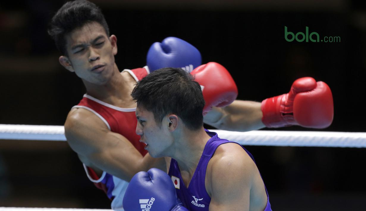 Aksi Grece Savon Simangunsong (merah) dan petinju Jepang, Hiroaki Kinjo beradu pukulan pada semifinal Test Event Asian Games 2018 kelas Welter di Kemayoran, Jakarta (14/2/2018). Simangunsong menang dengan skor 3-2. (Bola.com/Nick Hanoatubun)