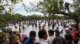Penduduk desa menangkap ikan selama upacara penangkapan ikan tahunan di komune Choam Krovean di provinsi Tboung Khmum pada 18 Februari 2023. Dengan menggunakan keranjang bambu buatan tangan dan jaring nilon, ratusan orang mengarungi danau berlumpur setinggi paha di Kamboja timur pada hari Sabtu untuk upacara penangkapan ikan tahunan, di mana hanya alat-alat tradisional yang digunakan. (AFP/Tang Chhin Sotthy)