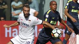 Gelandang Inter Milan, Joao Mario, berebut bola dengan gelandang Crotone, Andrea Barberis, pada laga Serie A Italia di Stadion Ezio Scida, Calabria, Sabtu (16/9/2017). Crotone kalah 0-2 dari Inter. (AFP/Carlo Hermann)