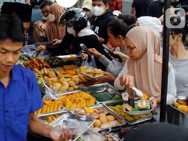 Pedagang melayani pembeli takjil menjelang waktu berbuka puasa di sepanjang Jalan Panjang, Kebon Jeruk, Jakarta, Selasa (4/4/2023). (Liputan6.com/Johan Tallo)