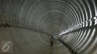 Seorang pekerja melintas di dalam terowongan mass rapid transit (MRT) yang masih dalam tahap penyelesaian di Bundaran Hotel Indonesia (HI), Jakarta, Senin (20/3). (Liputan6.com/Faizal Fanani)