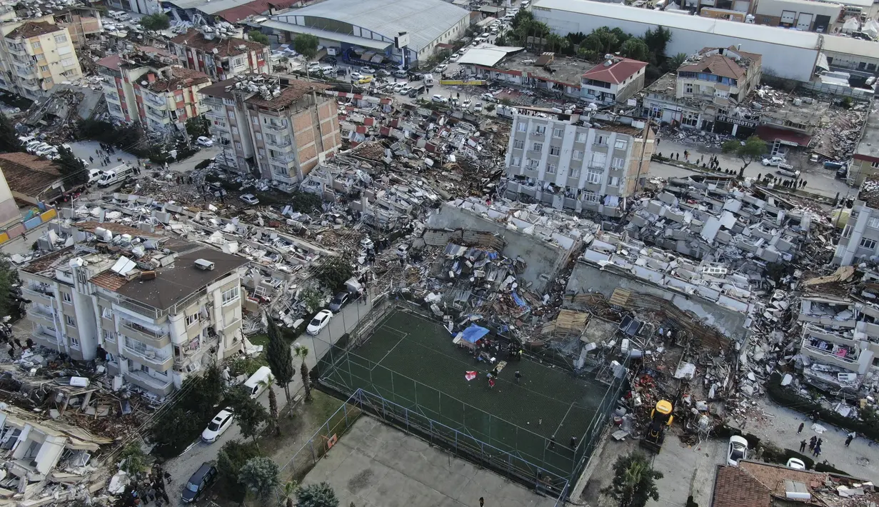Foto udara menunjukkan kehancuran di pusat kota Hatay, Turki selatan, Selasa (7/2/2023). Karena banyaknya gempa susulan, banyak warga di wilayah terdampak yang tak bisa berlindung di rumah dan memilih berada di mobil bersama anak-anaknya.  (IHA via AP)