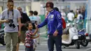 Pebalap Yamaha Movistar, Maverick Vinales, bercanda dengan seorang anak saat mendatangi paddock di Sirkuit Motegi, Tochigi Prefecture, Kamis (12/10/2017). MotoGP Jepang akan bergulir pada Minggu ini. (AP/Shizuo Kambayashi)