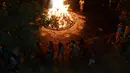 Warga melakukan ritual api unggun Holika di Ahmedabad, India, Minggu (12/3). Umat Hindu setempat menyalakan api unggun Holika pada malam sebelum festival Holi. (AFP PHOTO / SAM PANTHAKY)