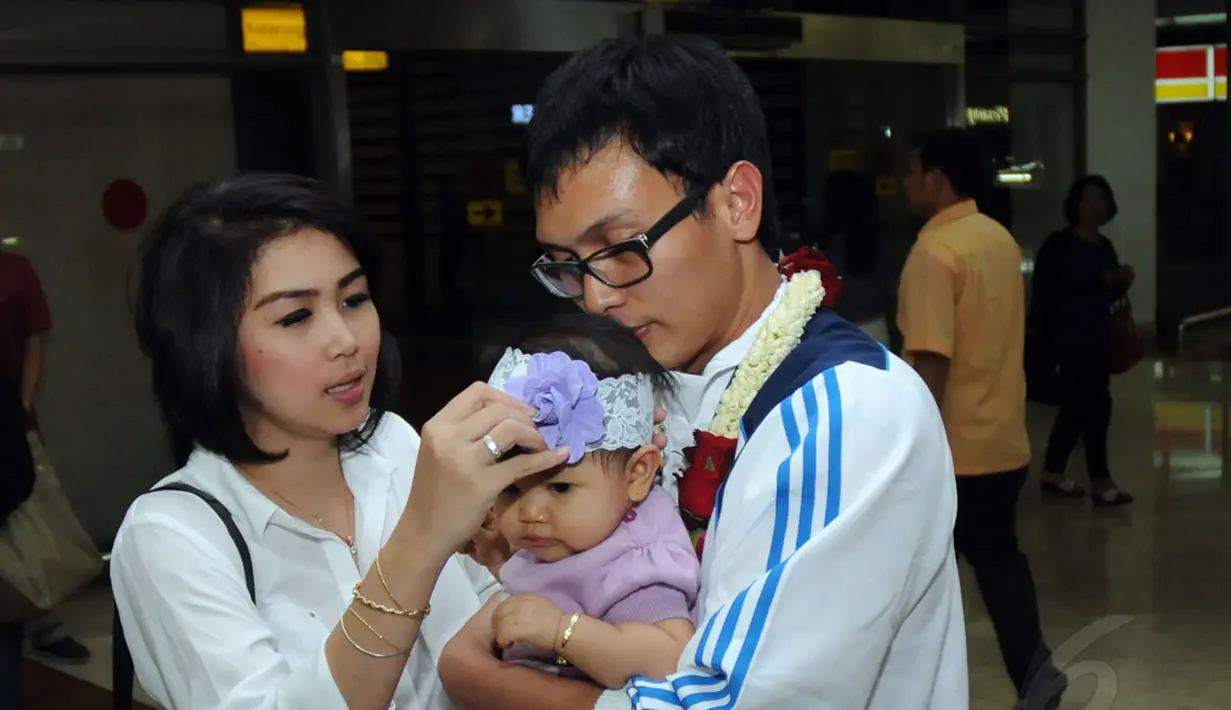 Pebulutangkis ganda putra, Mohammad Ahsan, memeluk buah hatinya sesaat setelah tiba di Bandara Soekarno-Hatta, Selasa (30/9/2014). (Liputan6.com/Helmi Fithriansyah)