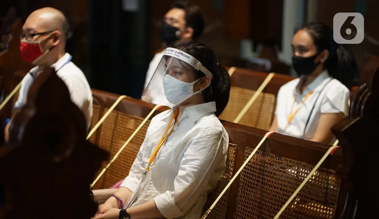 Jemaat duduk di antara pembatas jarak tubuh saat melaksanakan ibadah misa di Gereja Katedral Jakarta, Minggu (12/7/2020). Gereja Katedral Jakarta kembali menggelar misa bagi umat Katolik dengan menerapkan protokol kesehatan untuk mencegah penularan Covid-19. (Liputan6.com/Immanuel Antonius)