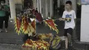 Seorang anak menjual bendera di sepanjang rute perlombaan perahu naga di kawasan bersejarah Teluk Lychee di Guangzhou di Provinsi Guangdong, China selatan, Jumat, 3 Juni 2022. Perlombaan perahu naga kembali digelar di beberapa bagian China untuk pertama kalinya sejak merebaknya pandemi pada akhir 2019, saat pembatasan dicabut bersama dengan penurunan besar  kasus COVID-19. (AP Photo/Caroline Chen)
