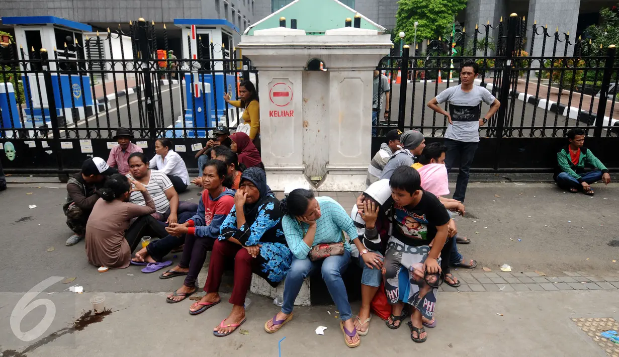 Warga Kalijodo terlihat duduk-duduk saat aksi di depan gedung DPRD DKI Jakarta, Jumat (19/2/2016). Dalam aksinya, mereka menuntut ganti rugi lahan pemukiman dan kepastian relokasi pemukiman. (Liputan6.com/Helmi Fithriansyah)