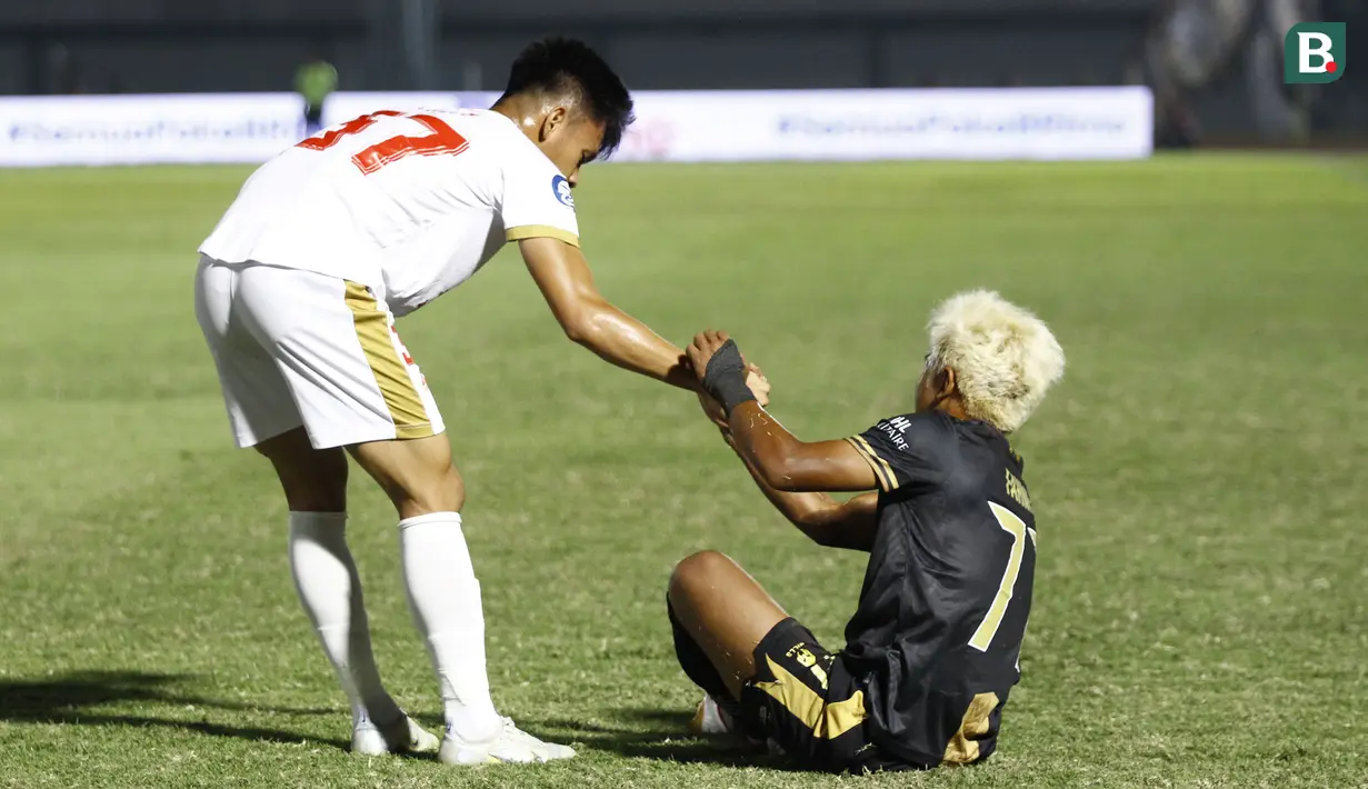 Pemain PSM Makassar, Muhammad Dzaki Asraf Huwaidi (kiri) membantu pemain Dewa United FC, Mochammad Fahmi Al Ayyubi bangkit usai keduanya bertabrakan dipinggir lapangan saat laga pekan ke-10 BRI Liga 1 2022/2023 antara Dewa United FC melawan PSM Makassar di Stadion Indomilk Arena, Tangerang, Kamis (15/9/2022). (Bola.com/Muhammad Aldiansyah)