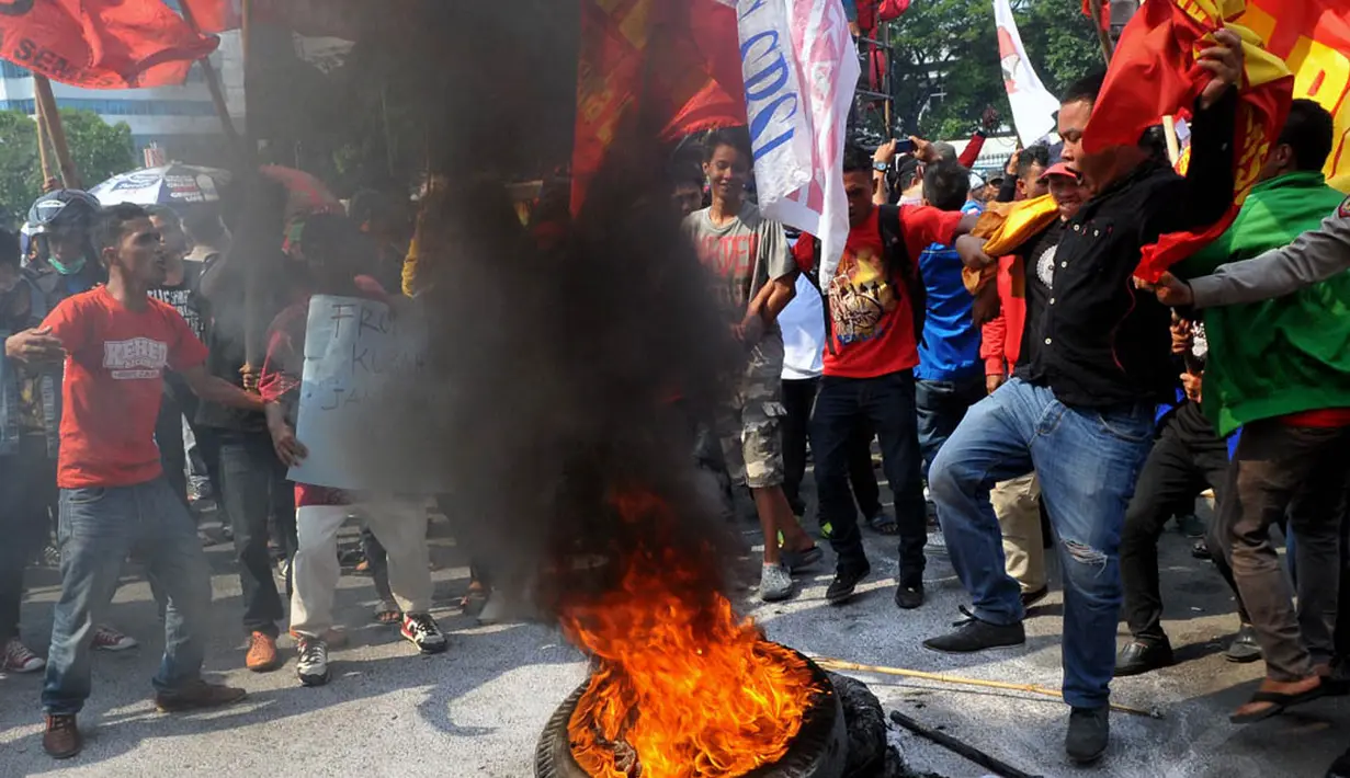 Aksi bakar ban mewarnai demonstrasi terkait RUU Pilkada di depan Gedung DPR, Jakarta, (25/9/14). (Liputan6.com/Johan Tallo)