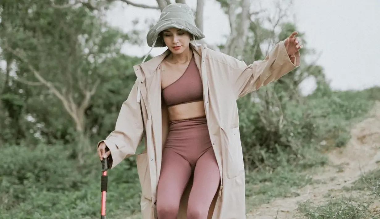 <p>Hiking juga ternyata salah satu kegemaran Kirana Larasati. Di sini terlihat ia sedang menikmati momen hiking mengenakan sport bra dan legging panjang yang senada, ditumpuk dengan long coat parasut, boonie hat, dan tongkatnya. Foto: Instagram.</p>
