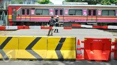 Warga mengambil gambar KRL yang melintasi perlintasan kereta api Stasiun Tebet, Jakarta, Kamis (7/4). Dishubtrans DKI melakukan uji coba penutupandan pengalihan arus lalu lintas di bawah flyover Tebet tepat depan Stasiun Tebet. (Liputan6.com/Yoppy Renato)