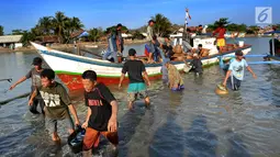 Nelayan menurunkan ikan hasil tangkapannya di Tempat Pelelangan Ikan (TPI) Palangpang, Ciletuh, Sukabumi, Jawa Barat, (23/9). Nelayan mengaku tangkapan ikan membaik sejak dua bulan terakhir. (Merdeka.com/Arie Basuki)
