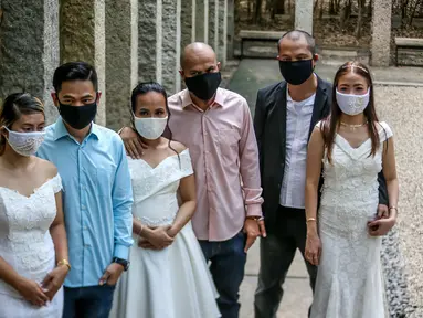 Para pasangan mengenakan masker terlihat dalam "pernikahan massal bermasker" di sebuah taman di Kota Makati, Filipina (15/12/2020). Pemerintah Filipina telah memberlakukan kebijakan untuk penggunaan masker di tengah kekhawatiran lonjakan kasus COVID-19 selama musim liburan. (Xinhua/Rouelle Umali)