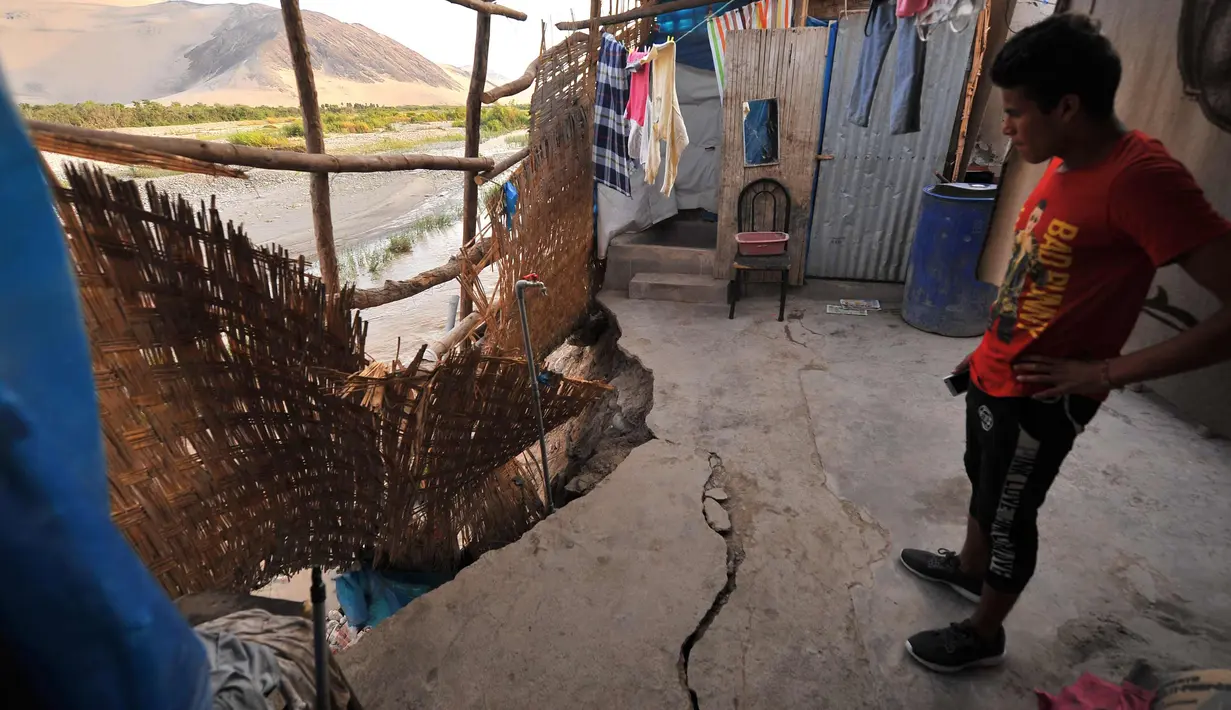 Seorang pria melihat kerusakan akibat gempa di rumahnya di sebelah Sungai Acari di kota Acari, provinsi Arequipa di Peru selatan (14/1). (AFP Photo/Str)