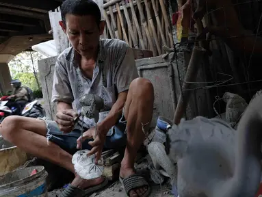 Pengrajin membuat patung di Jakarta, Jumat (16/3). Pemerintah berencana menurunkan tarif pajak penghasilan atas penjualan dibawah Rp4,8 miliar yang dikenakan tarif PP 46 sebesar 1% per bulan dari jumlah omzet, menjadi 0,5%. (Liputan6.com/Angga Yuniar)