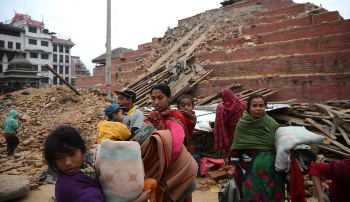 Sejumlah warga Nepal terlihat hilir mudik di sekitar Kathmandu Durbar Square yang rusak parah, Minggu (26/4/2015). Gempa berkekuatan 7,8 Skala Richter itu dikabarkan telah menghancurkan ribuan rumah termasuk bangunan bersejarah (AFP Photo/Prakash Mathema)