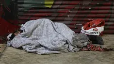 Seorang tunawisma tidur di atas trotoar saat malam dengan cuaca dingin di pusat kota Sao Paulo, 19 Juli 2017. Menurut pejabat setempat, setidaknya 16.000 tunawisma tinggal di kota Sao Paulo. (AP Photo / Andre Penner)