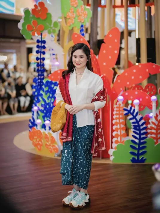 Tissa Biani tampil mengenakan kebaya putih modern dipadukan kain lilit batik hijaunya. Ia pun menambahkan selendang kain merahnya. Credit: (@tissabiani)