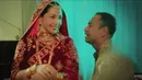 Nagita juga mengenakan aksesori merah keemasan, dari hiasan kepala, anting-anting besar dan panjang, gelang-gelang, serta kalung menutupi leher. [YouTube Dewa19]