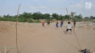 Anak-anak saat bermain sepakbola di tanah sengketa kawasan Pedongkelan, Jakarta, Kamis (11/7/2019). Meski bertempat tinggal di atas lahan sengketa, anak-anak setempat memanfaatkan tanah kosong yang penuh semak belukar tersebut sebagai sarana bermain ketika sore hari. (merdeka.com/Iqbal S. Nugroho)