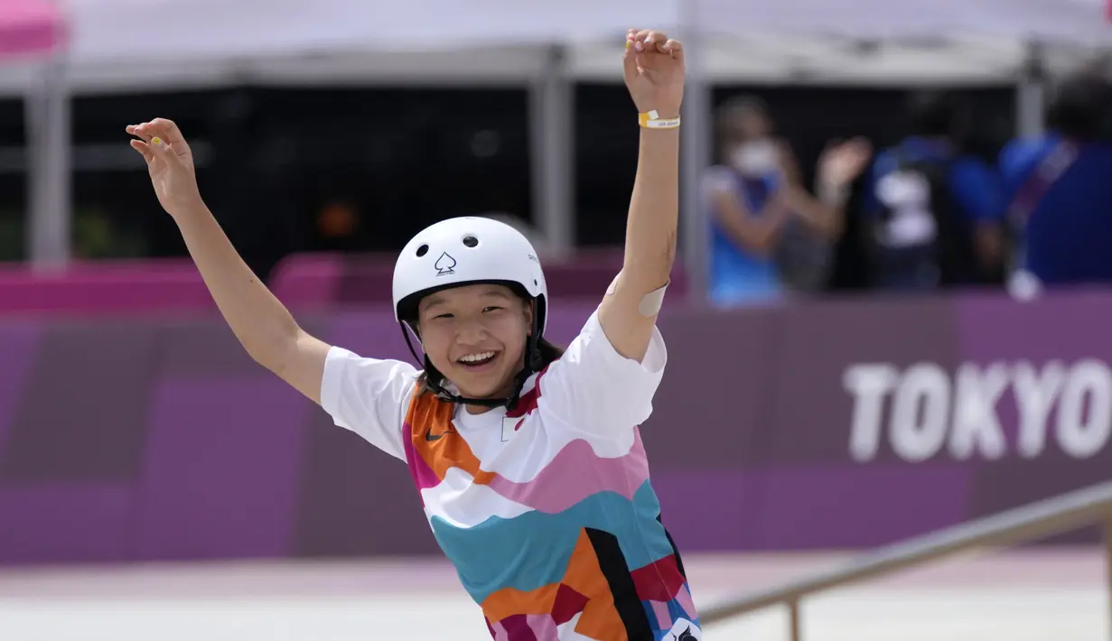 Skater Jepang Momiji Nishiya tersenyum setelah memenangkan final street skateboarding putri Olimpiade Tokyo 2020 di Tokyo, Jepang, 26 Juli 2021. Tampil di Ariake Park, Momiji mengukir rekor di buku sejarah Olimpiade usai meraih medali emas pada women's street. (AP Photo/Ben Curtis)