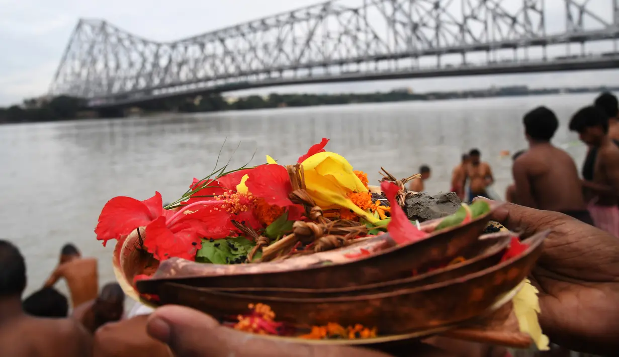 Umat Hindu melakukan ritual 'Tarpan' pada hari Pitrupaksh di Sungai Gangga di Kolkata (19/9). Hari Pitrupaksh menggambarkan hari ketika para dewa menciptakan dewi dewi untuk menghancurkan raja setan Asura. (AFP Photo/Dibyangshu Sarkar)