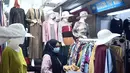 Pengunjung melihat-lihat baju di Pasar Tanah Abang Blok A, Jakarta, Rabu (19/5/2021). Pada hari ini, Pasar Tanah Abang kembali dibuka setelah ditutup sementara selama sepekan pada 12-18 Mei 2021. (Liputan6.com/Herman Zakharia)