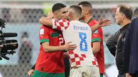 Bintang Maroko yang bermain untuk PSG, Achraf Hakimi pun berusaha dihibur oleh Mateo Kovacic, yang seakan memberi semangat dan mengakui perjalanan hebat Timnas Maroko di Piala Dunia 2022. (AFP/Karim Jaafar)