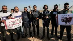 Sejumlah wartawan Palestina melakban mulut mereka saat menggelar aksi protes di dekat perbatasan Israel-Gaza, Palestina (8/4). Mereka menggelar protes terkait pembunuhan wartawan Yasser Murtaja yang mati ditembak tentara Israel. (AFP Photo/Said Khatib)