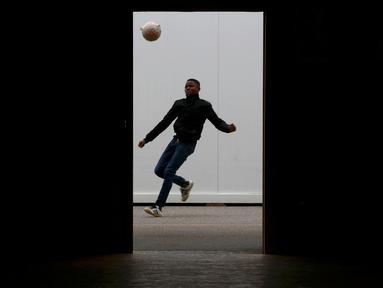 Seorang anak laki-laki migran bermain bola di luar Pusat Pengungsi Federal Swiss Federal di Thun, Swiss, (22/3/2016). (Reuters/Ruben Sprich