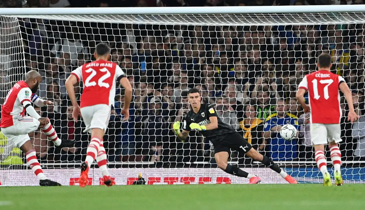 Pemain Arsenal Alexandre Lacazette (kiri) mencetak gol ke gawang AFC Wimbledon pada pertandingan Piala Liga Inggris di Emirates Stadium, London, Inggris, 22 September 2021. Arsenal menang 3-0. (JUSTIN TALLIS/AFP)